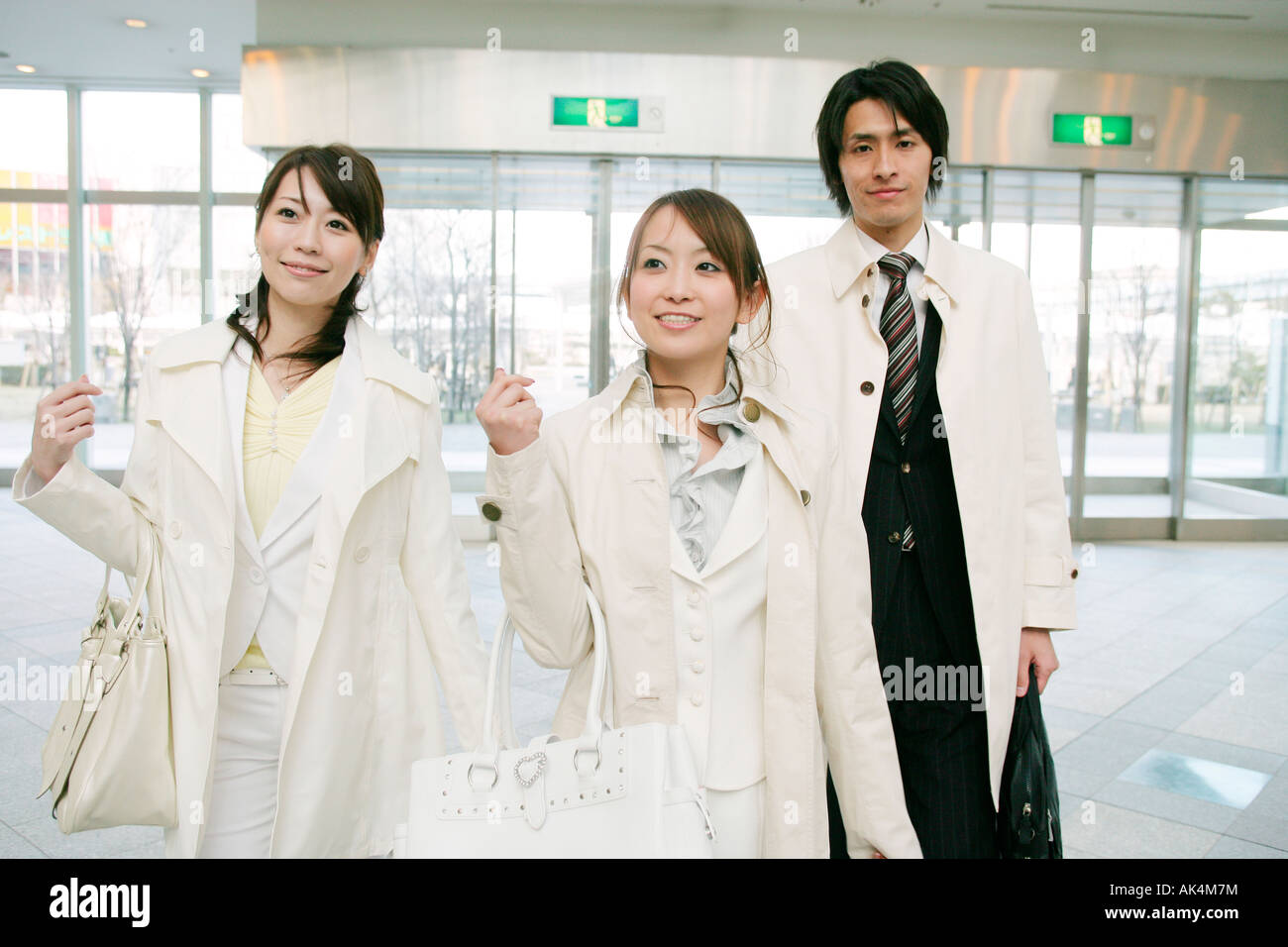 Businessman and two women walking Stock Photo - Alamy