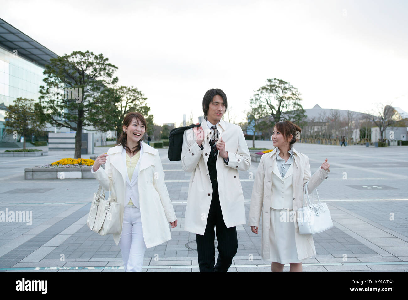 Businessman and two women walking Stock Photo - Alamy