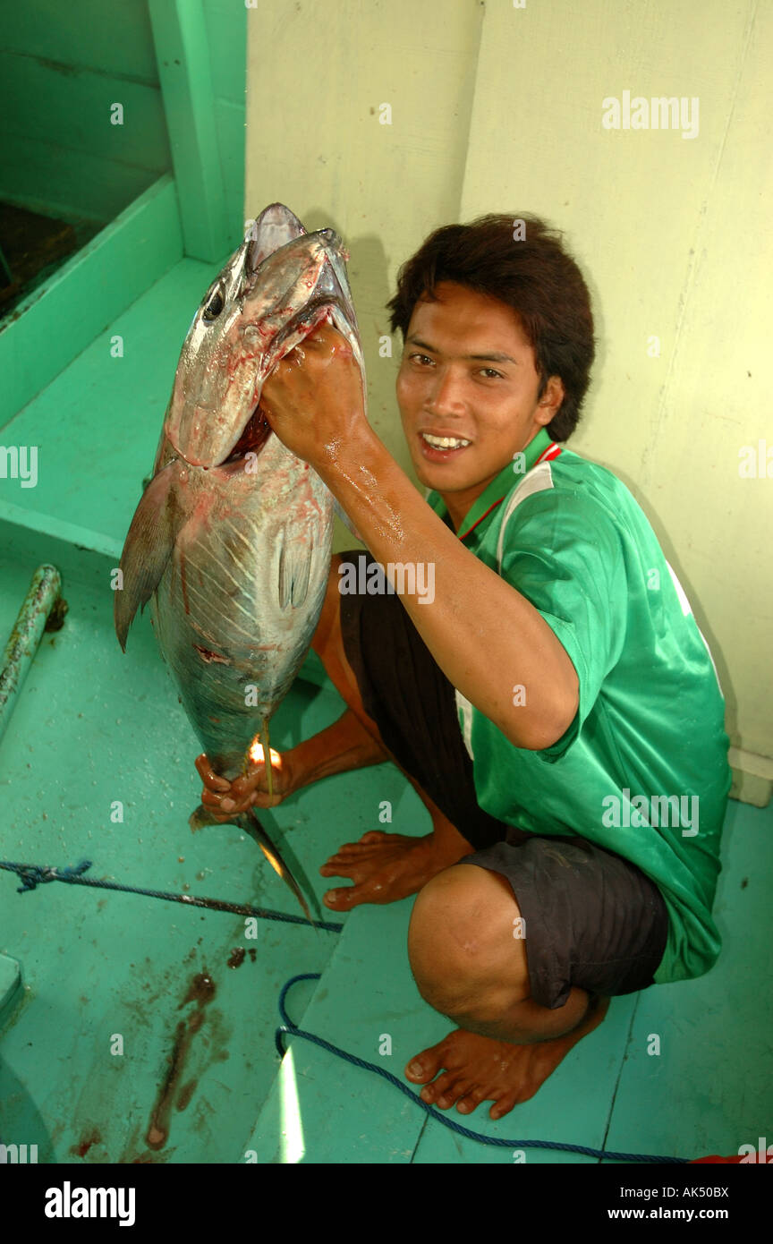 fisherman on boat in indonesia holding yellow fin tuna fish Stock Photo