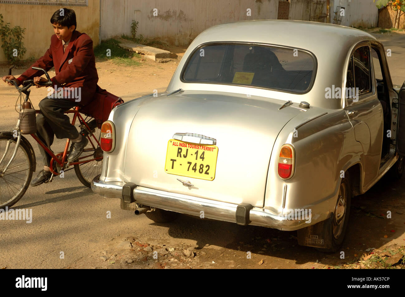 Silver Indian Ambassador Car with schoolboy passing on a pushbike Stock Photo