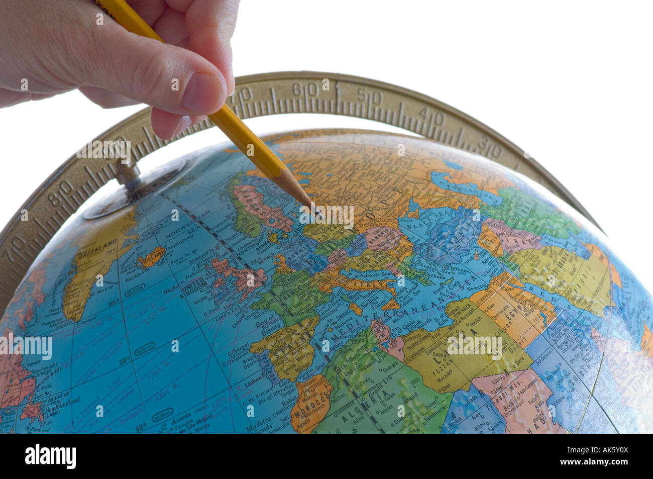 woman's hand pointing pencil at Europe on globe in classroom Stock Photo