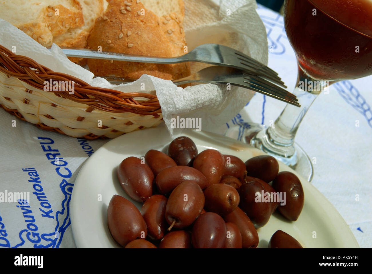 Restaurant table in Corfu laid with a simple Greek meal of bread olives and wine Stock Photo