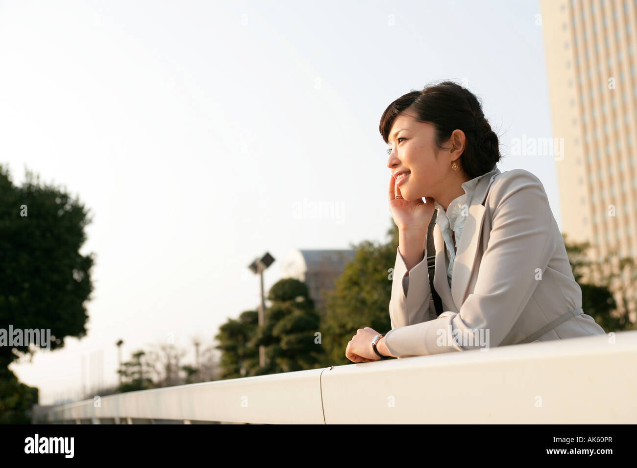 Businesswoman leaning against railing hi-res stock photography and ...
