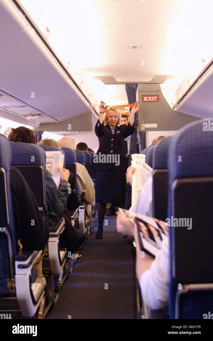 Female cabin crew member demonstrating safety drill before take off
