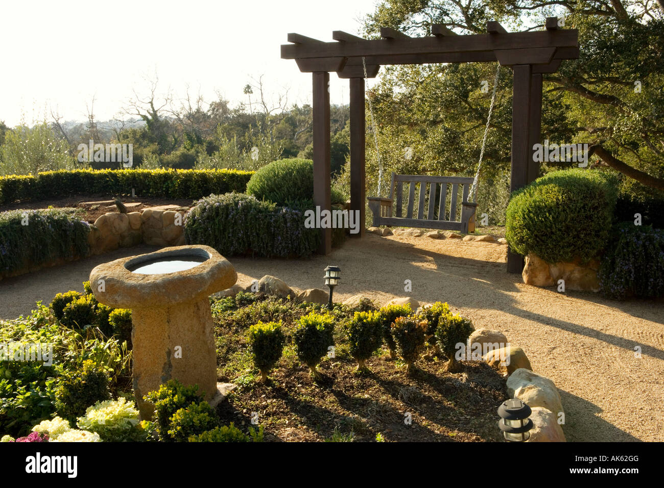 Spanish Style Courtyard with Swing and Bird Bath Stock Photo - Alamy