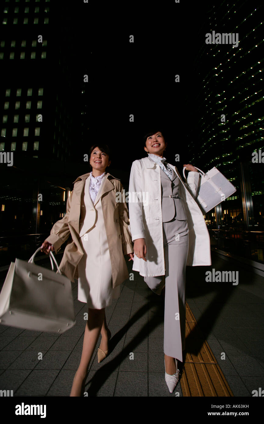 Two women walking on the street at night, low angle Stock Photo - Alamy