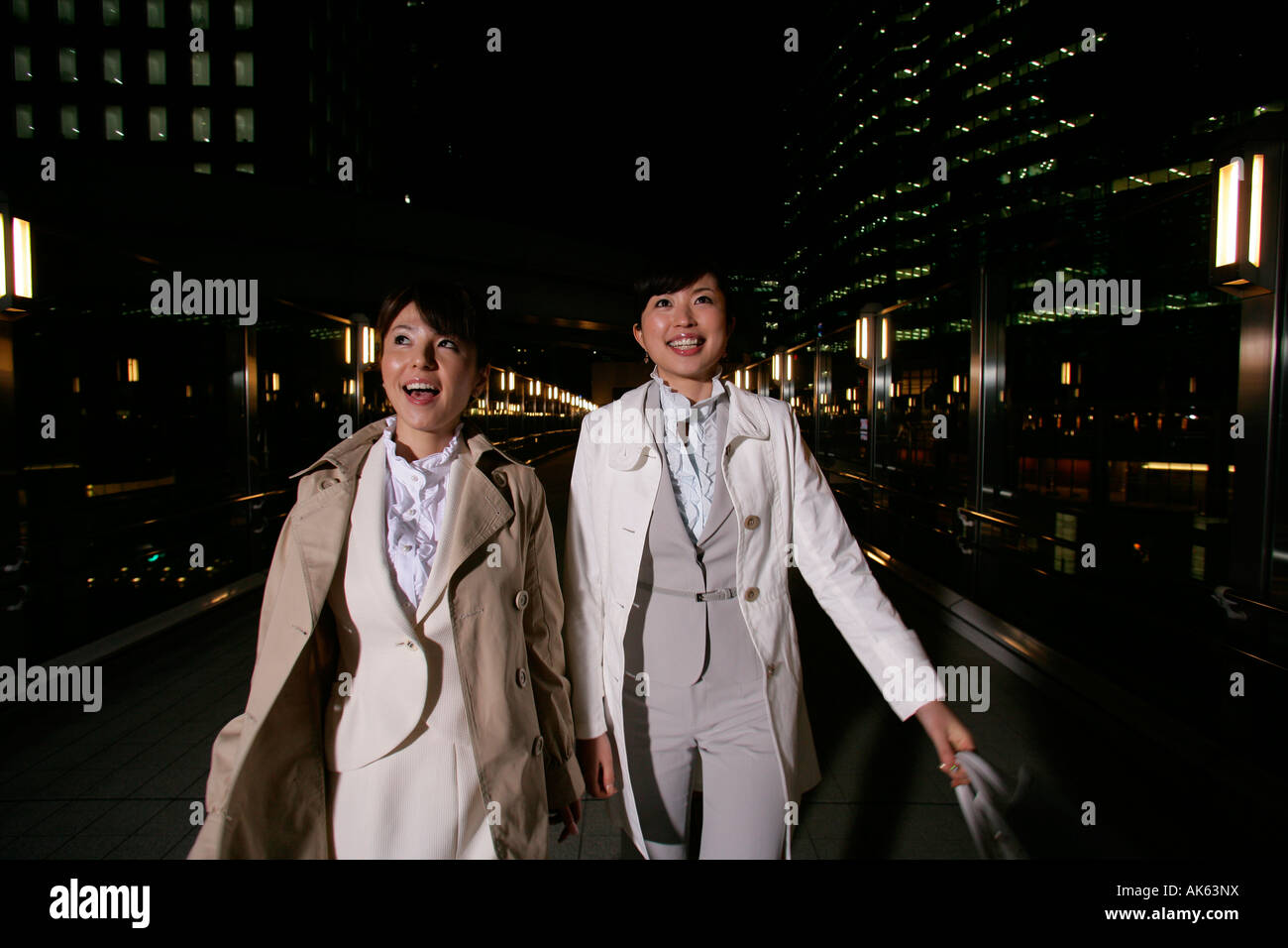 Two women walking on the street at night Stock Photo - Alamy