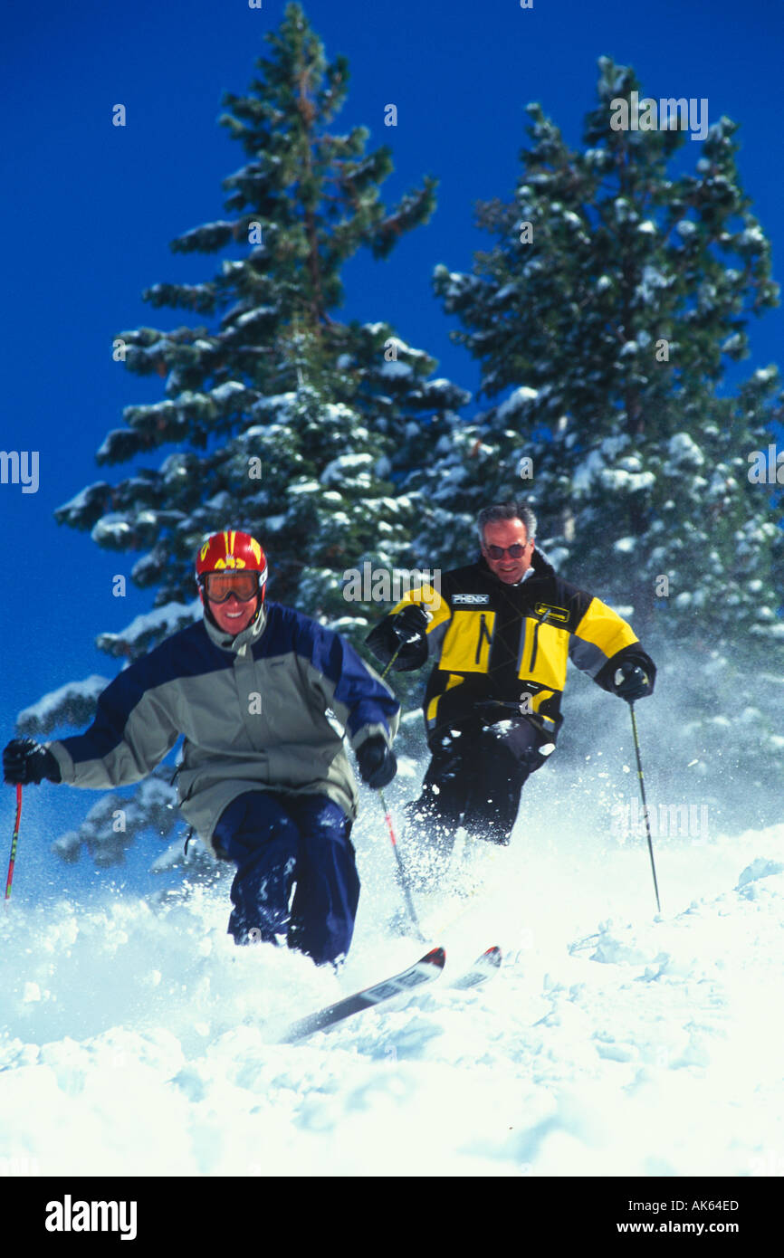 Skiers riding down a snow covered hill Stock Photo Alamy