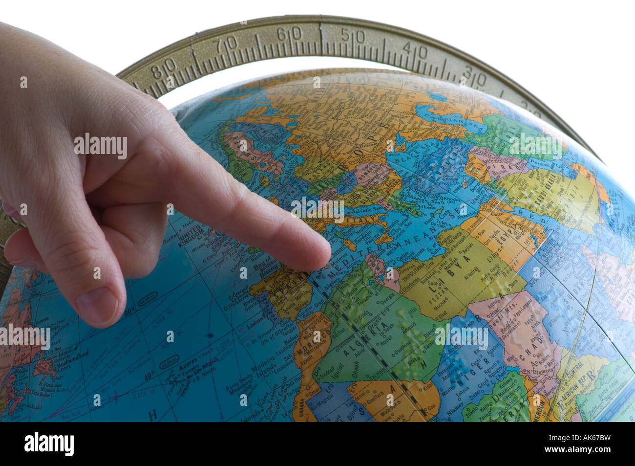 woman's hand pointing to Europe on globe in classroom Stock Photo