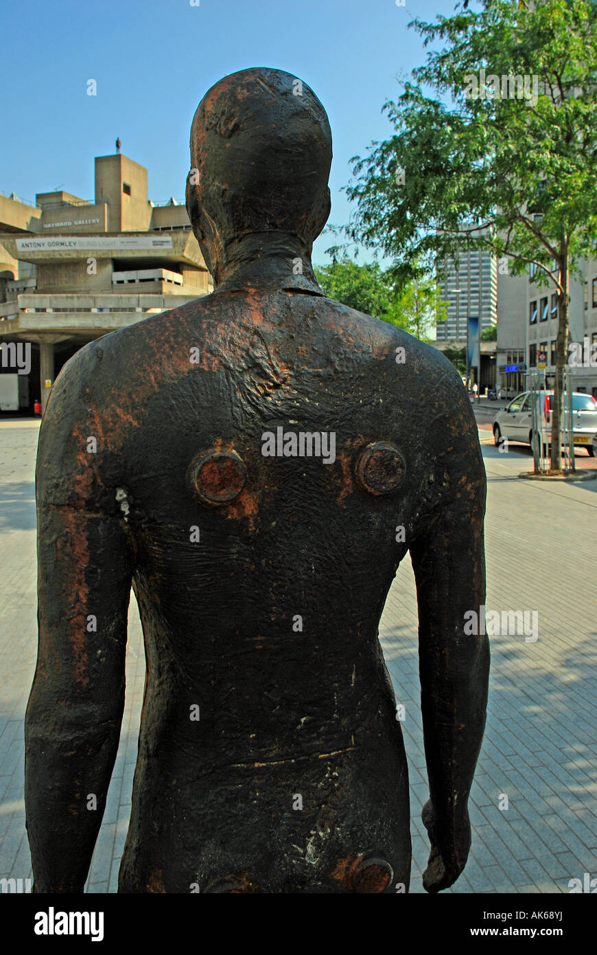 Antony Gormley figure looking at another figure on a distant rooftop as