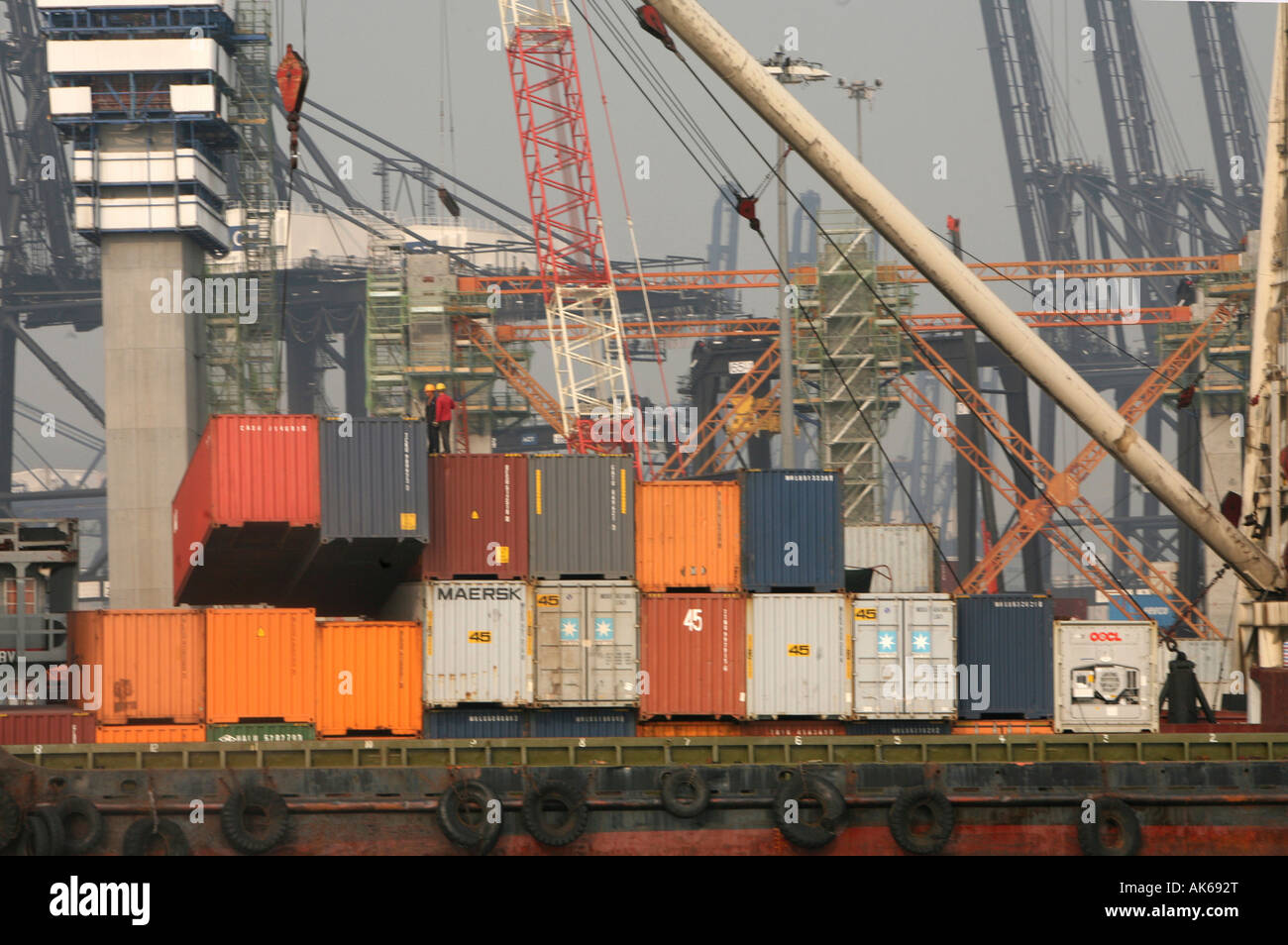 Thousands of containers move by barges from port to container ships and ...