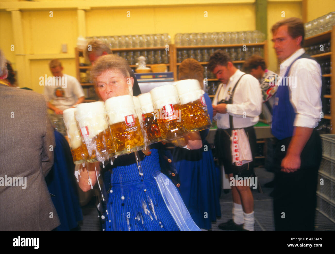 Waitress dressed in dirndl serving Liter glasses of beer in Oktoberfest Theresienwiese Munich Bavaria Germany Stock Photo