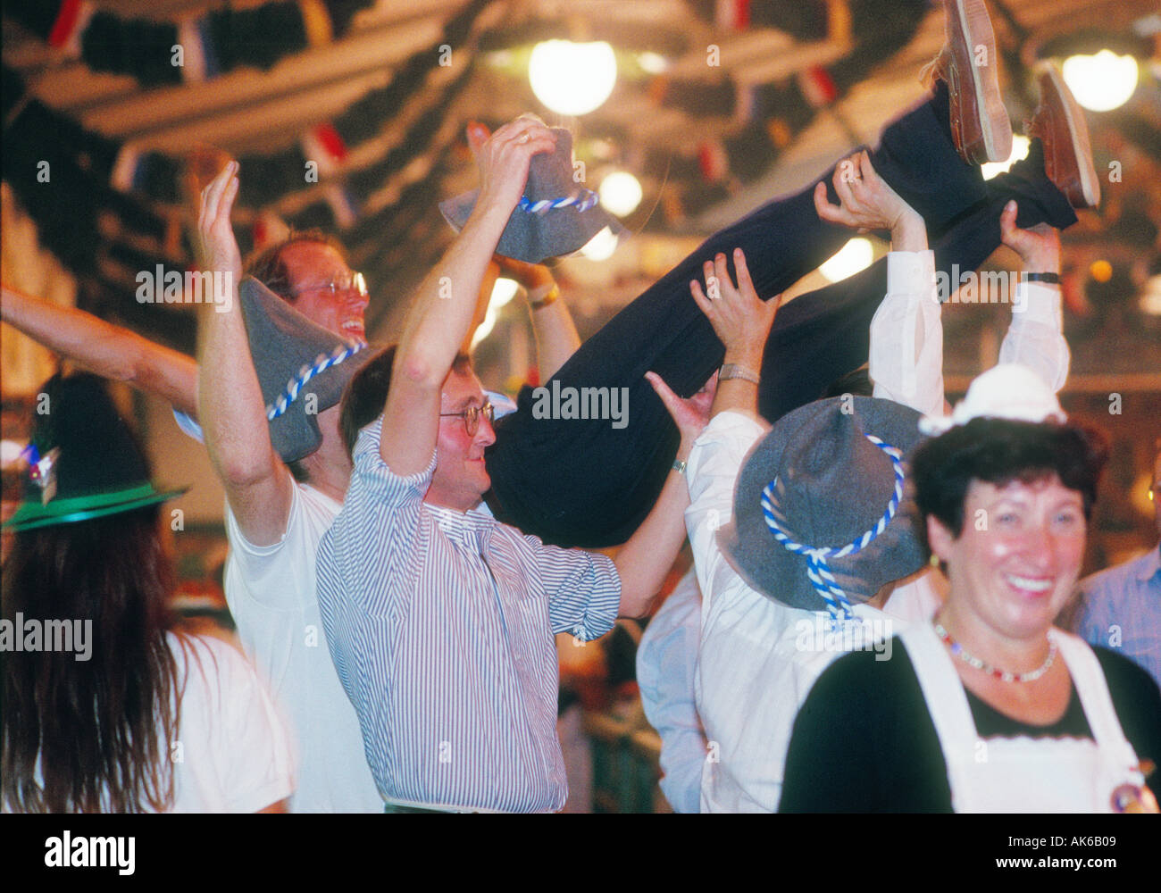Europe Germany Munich Beer Festival Oktoberfest people dancing and drinking in tent hall and partying. Stock Photo