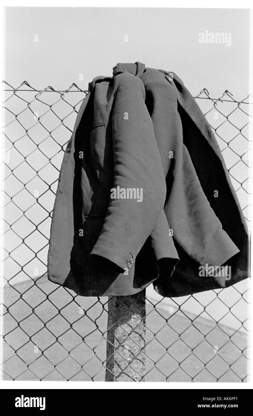 Workmans Coat Hanging on Fence Stock Photo
