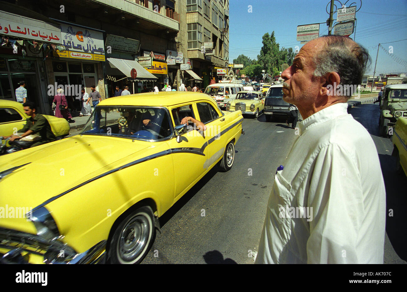 Old Man in Traditional Dress Crossing a Busy Street in Hama, Syria Stock Photo