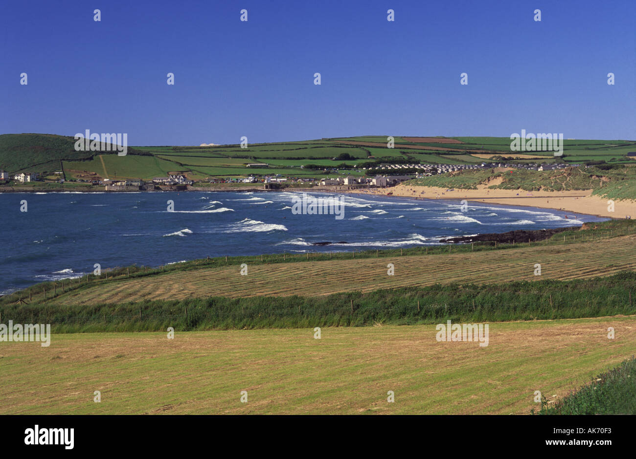 View north over Croyde Bay with Downend Field in foreground surfers in water and Baggy Point beyond Devon England Stock Photo