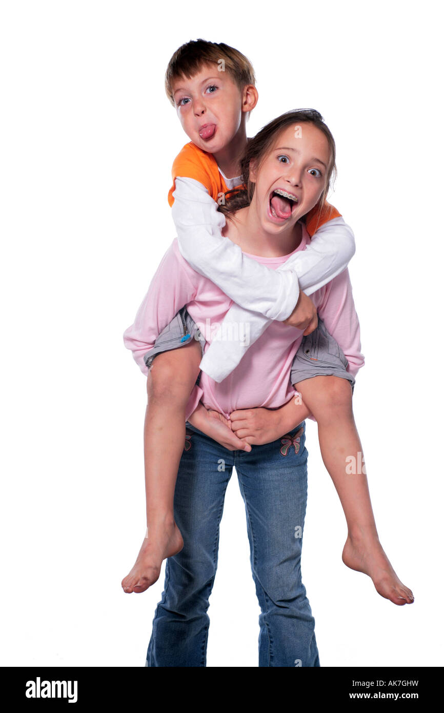 Photo of a Sister giving her Brother a Piggy Back Ride They are making big funny faces Stock Photo