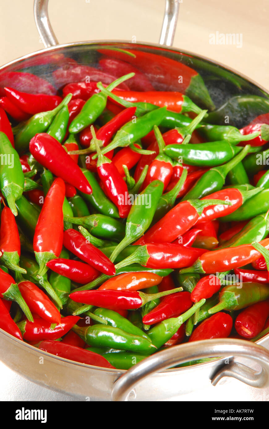 Red and green ripe and unripe bird's eye chillies in a bowl. Stock Photo