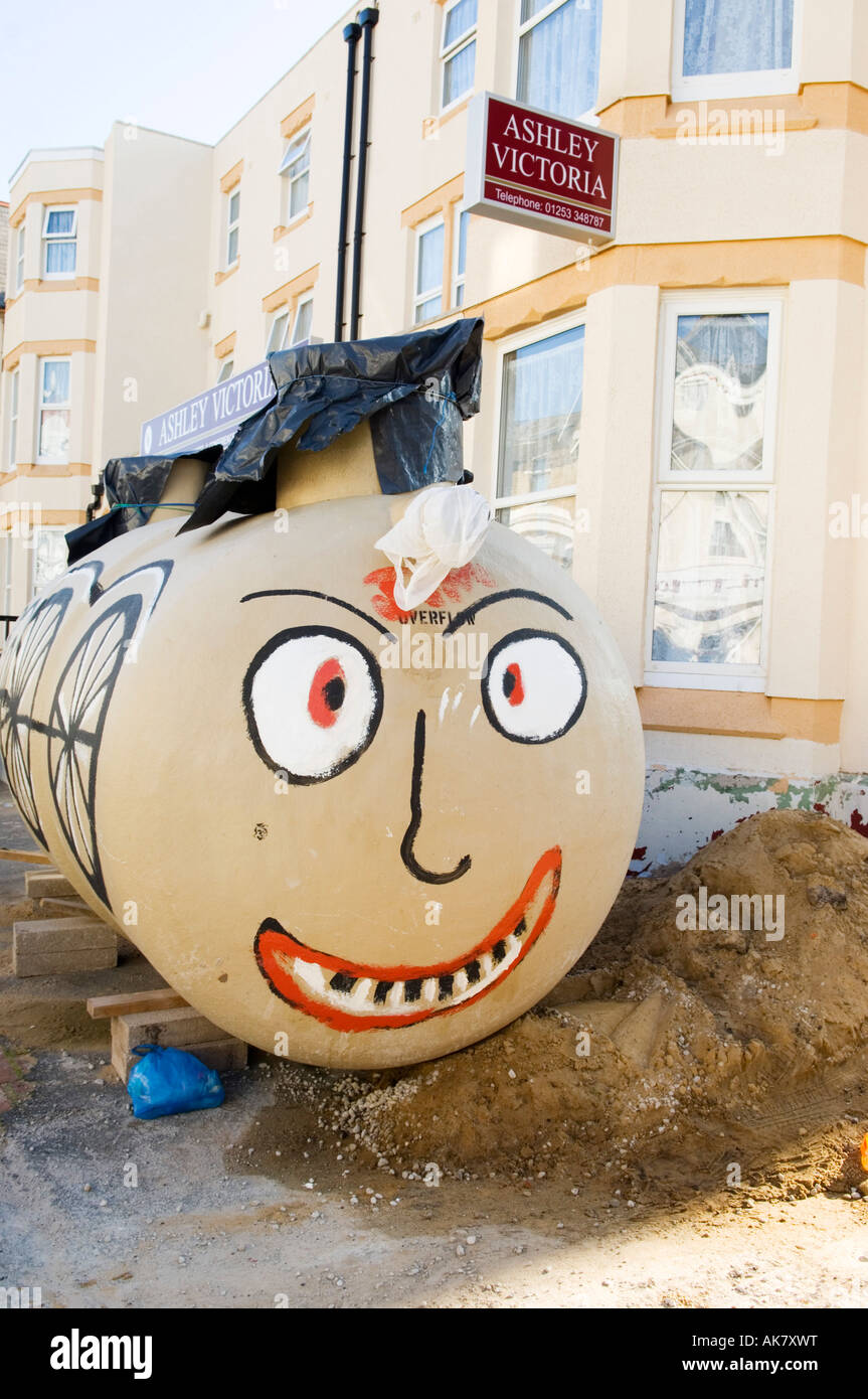 Painted face on water tank in front of hotel during building work Stock Photo