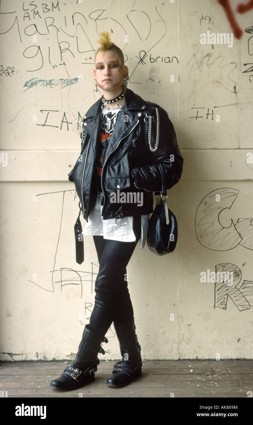 Punk girl standing beside a graffiti wall Stock Photo