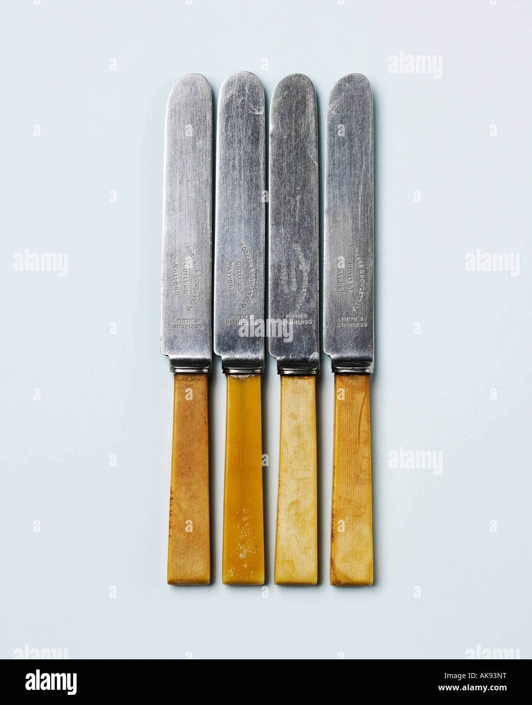 Four old knives on a light blue background Stock Photo