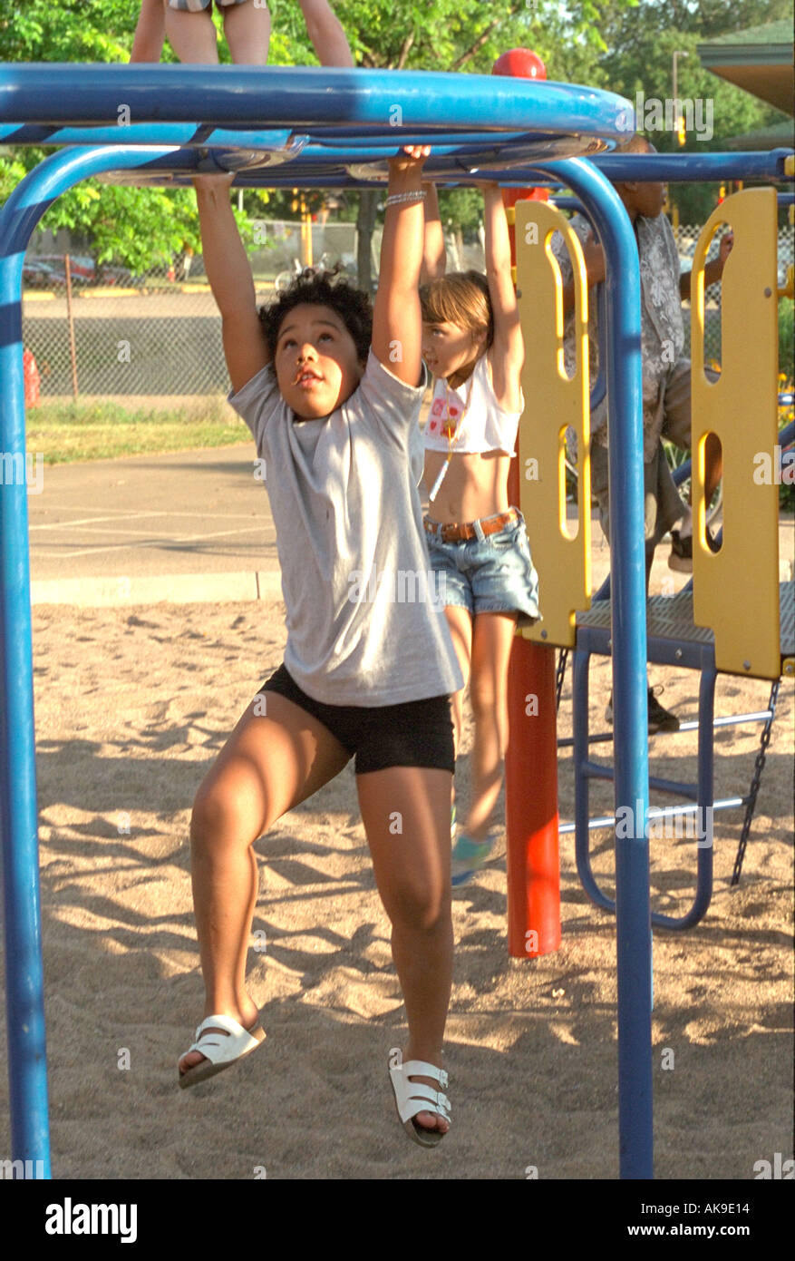 Friends on monkey bars age 10 Youth Express 10th anniversary party. St Paul Minnesota USA Stock