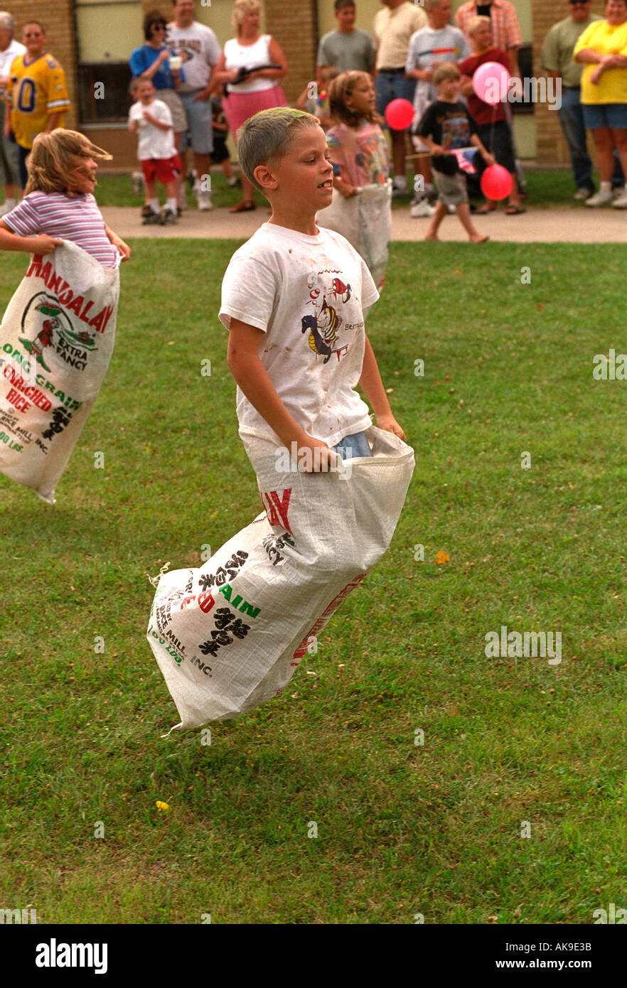 Kids age 11 in potato sack race in Watermelon Days Festival. Vining Minnesota USA Stock Photo