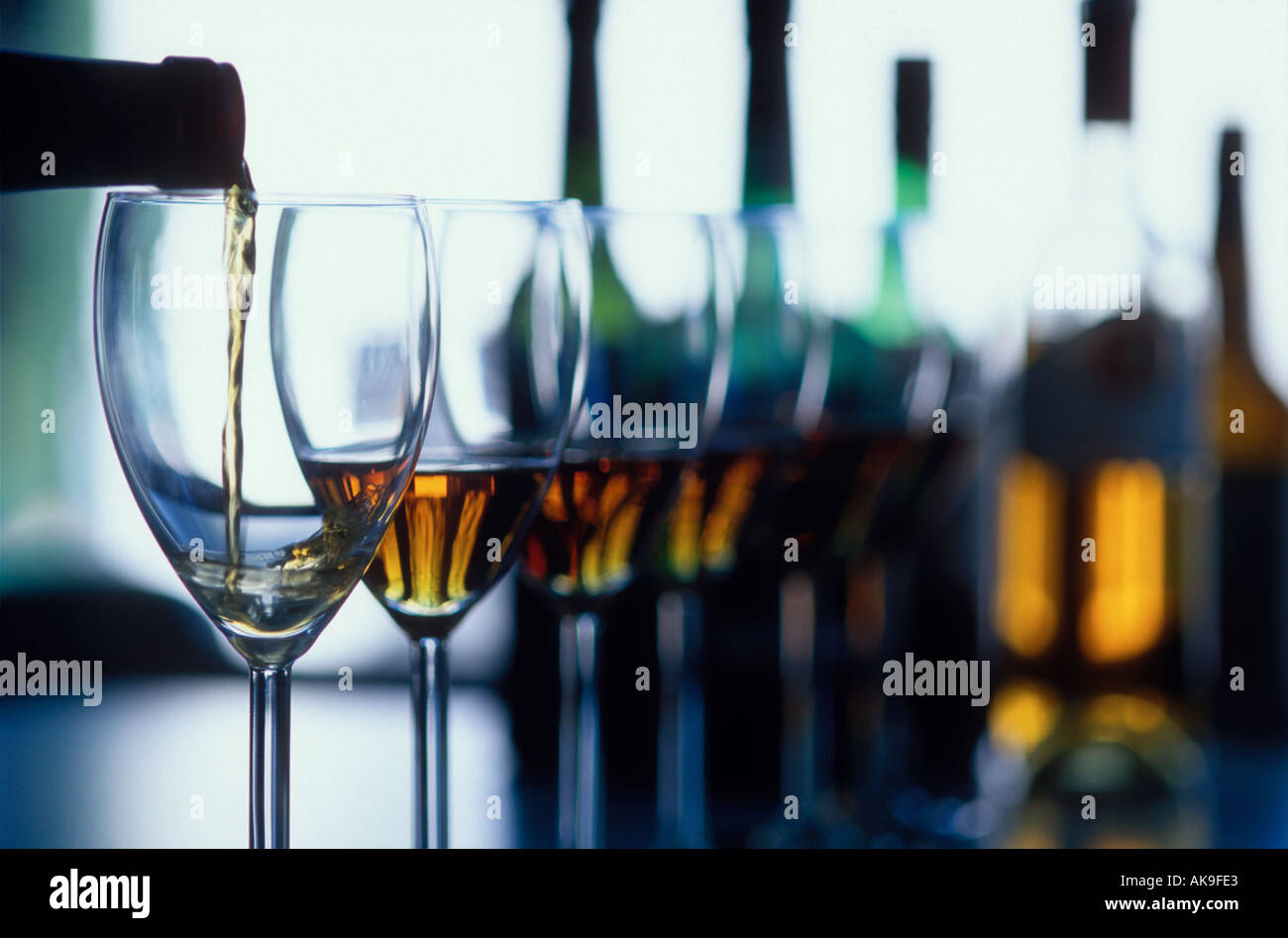pour shot of wine in glasses line up Stock Photo - Alamy