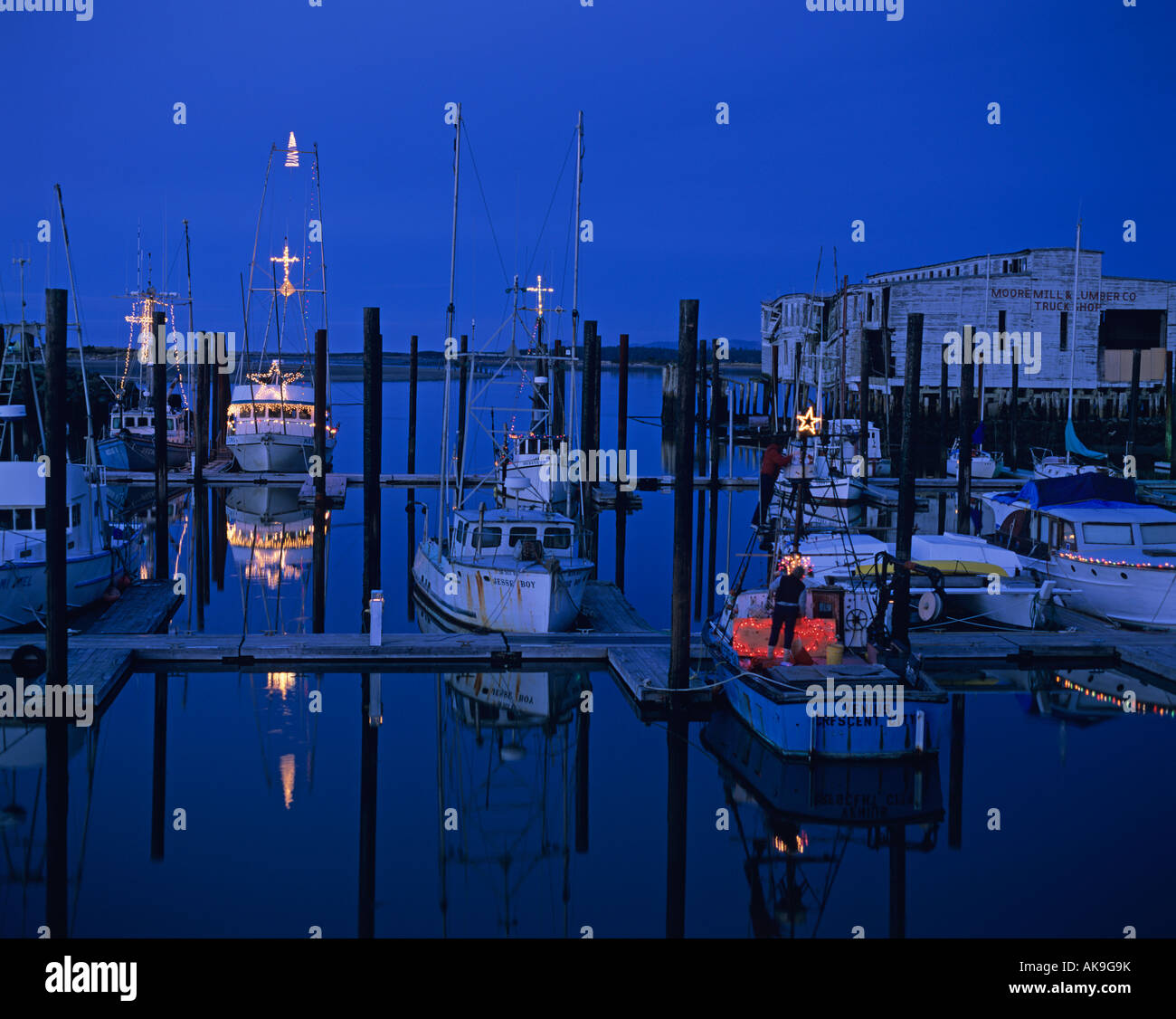 Fishing boats at marina with Christmas lights at twilight along the
