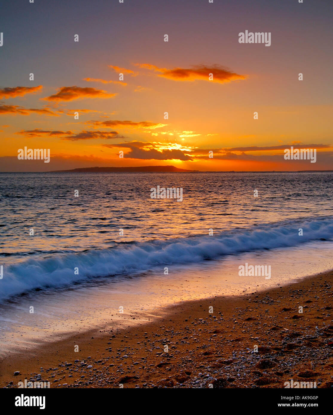 Sunset on the Dorset coast looking out to sea from the base of Swyre Head with the Isle of Portland on the horizon Stock Photo