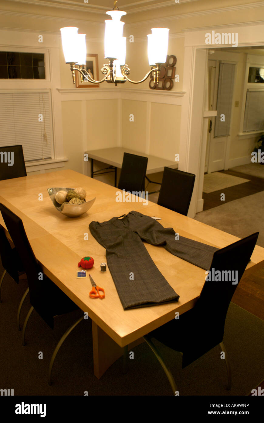 Pants And Sewing Equipment On A Dining Room Table Stock