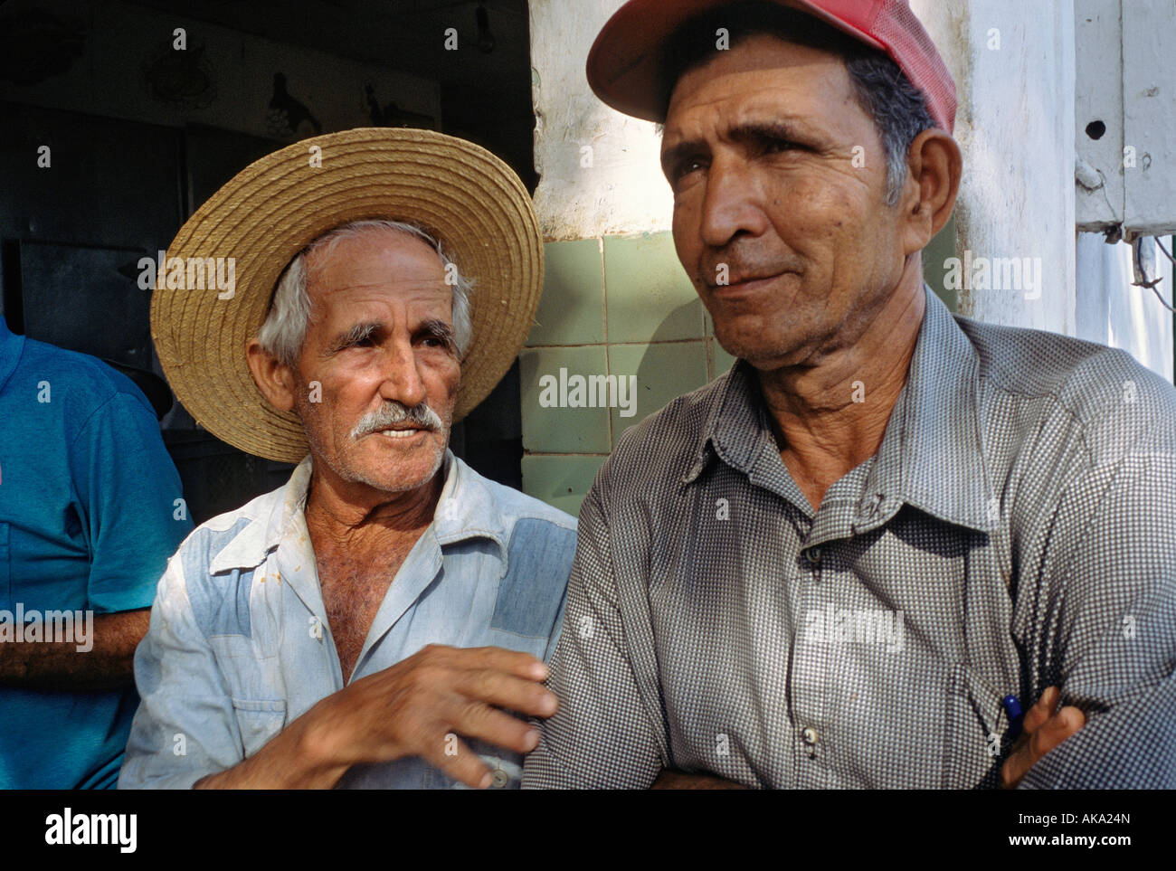 Two men in front of a market in Habana Libre a sugar production town or batey in the Province of La Habana Cuba Stock Photo