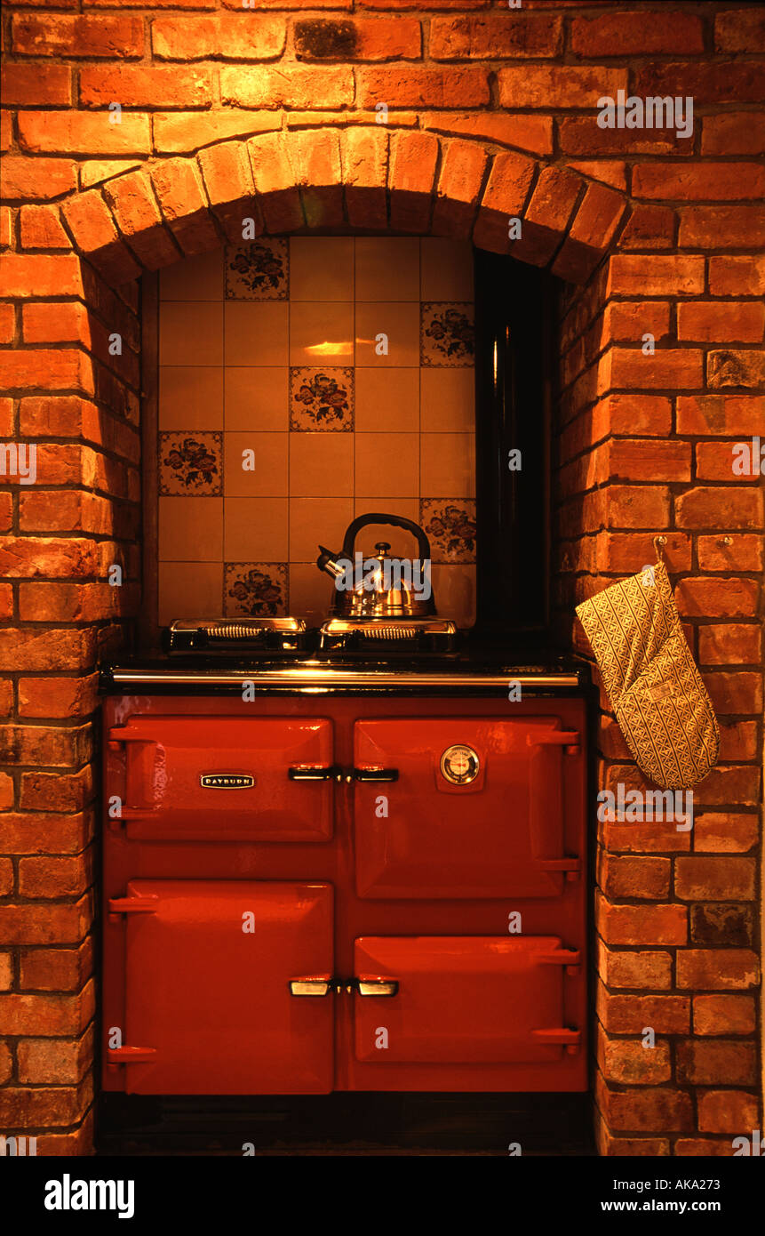 Red Rayburn cooker in a brick alcove Stock Photo