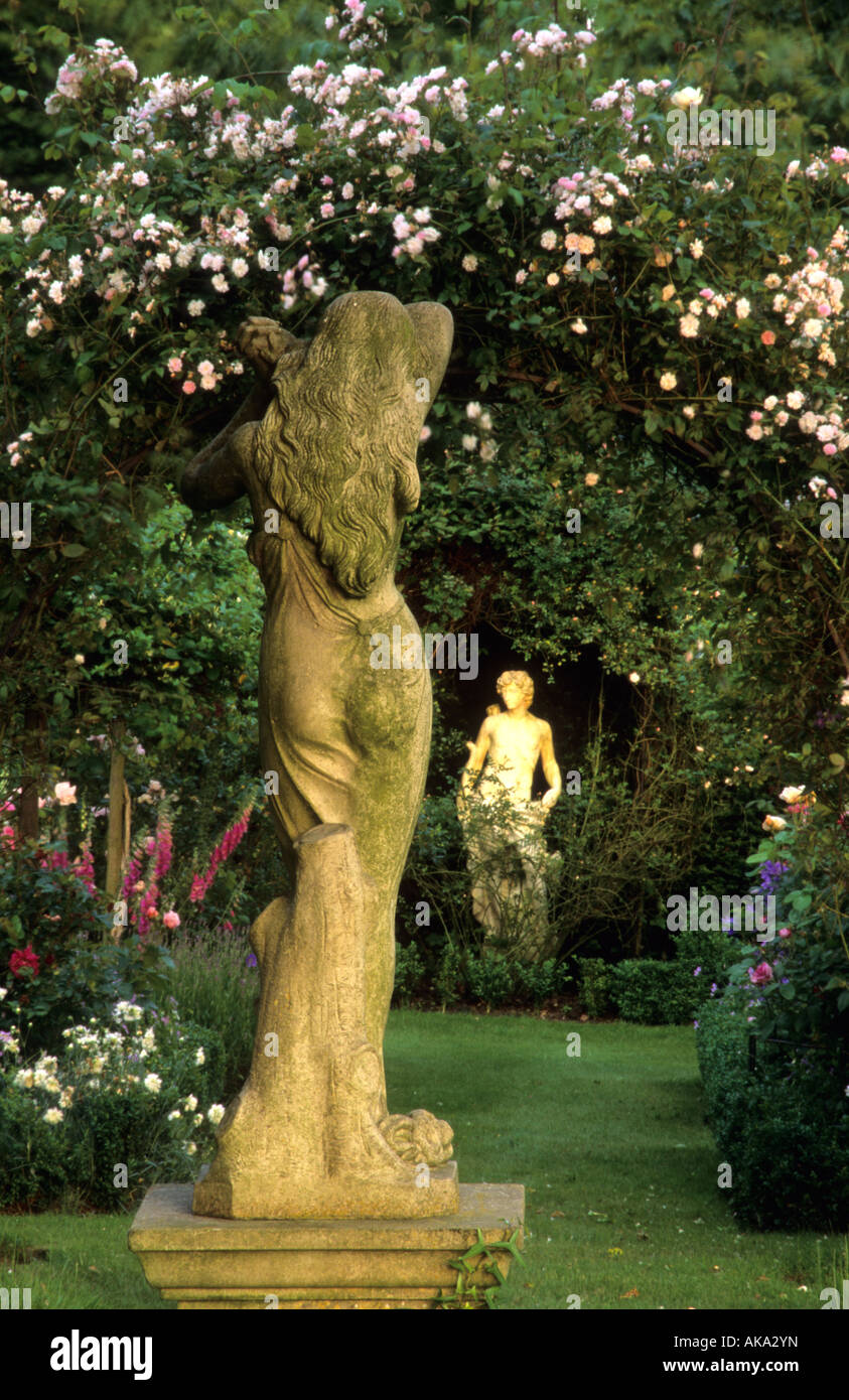 private garden Sussex stone figurative statues at sunset in lovers rose garden Stock Photo
