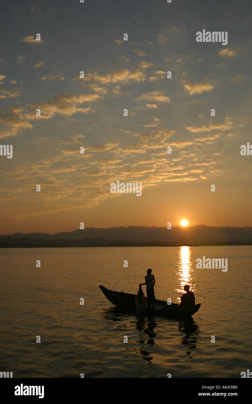 On Kaptai Lake a fisherman and his son pull in their morning nets Stock Photo