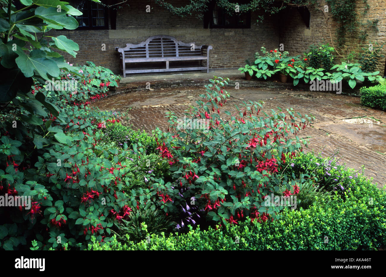 Munstead Wood Surrey Gertrude Jekyll s garden courtyard with Lutyens bench and Fuchsias Stock Photo