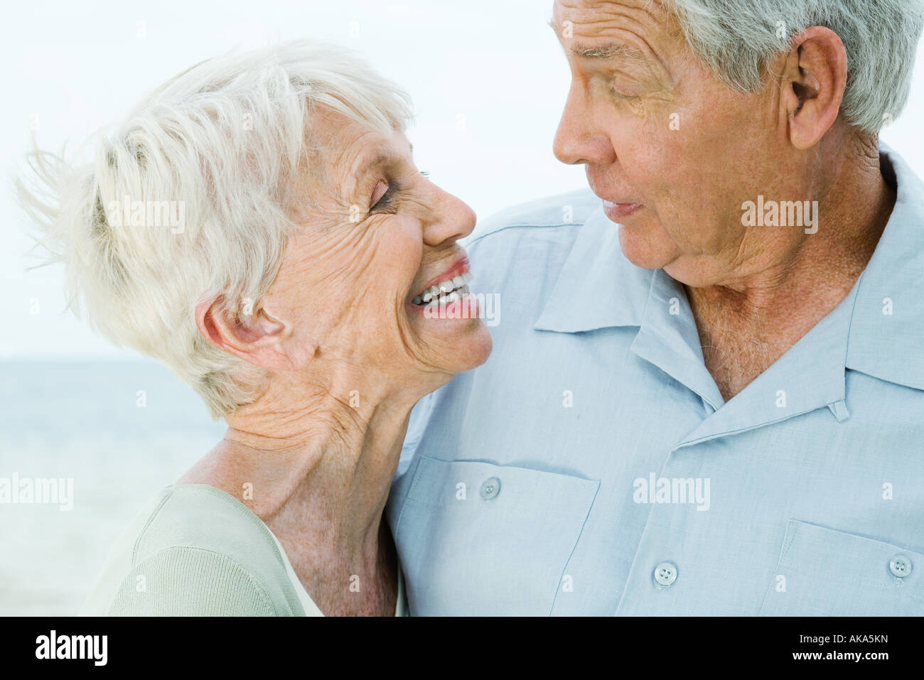 Senior couple looking at each other, woman smiling, man raising eyebrows Stock Photo