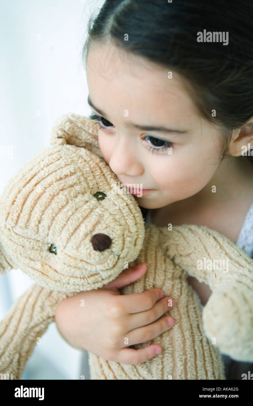 Little girl holding teddy bear, looking away, portrait Stock Photo - Alamy