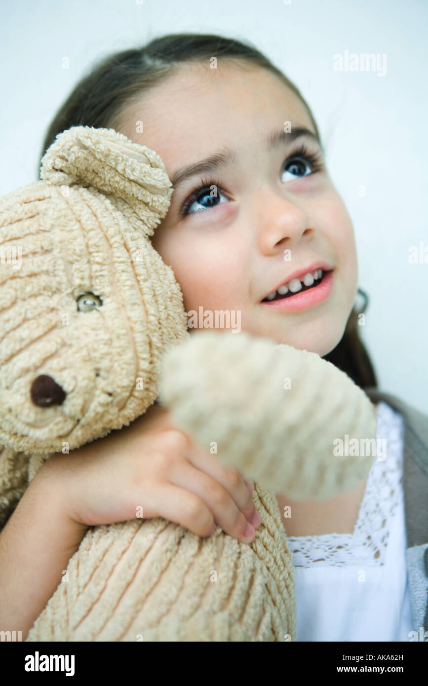 Little girl holding teddy bear, looking up, portrait Stock Photo - Alamy