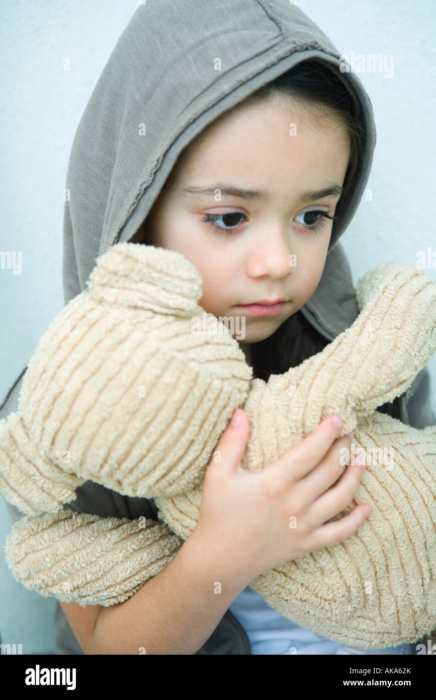 Little girl holding teddy bear, looking down, portrait Stock Photo - Alamy