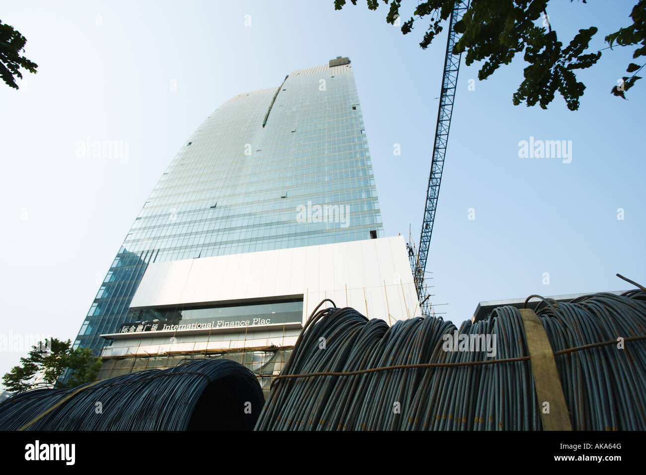China, Guangdong Province, Guangzhou, skyscraper under construction and reels of cable, low angle view Stock Photo