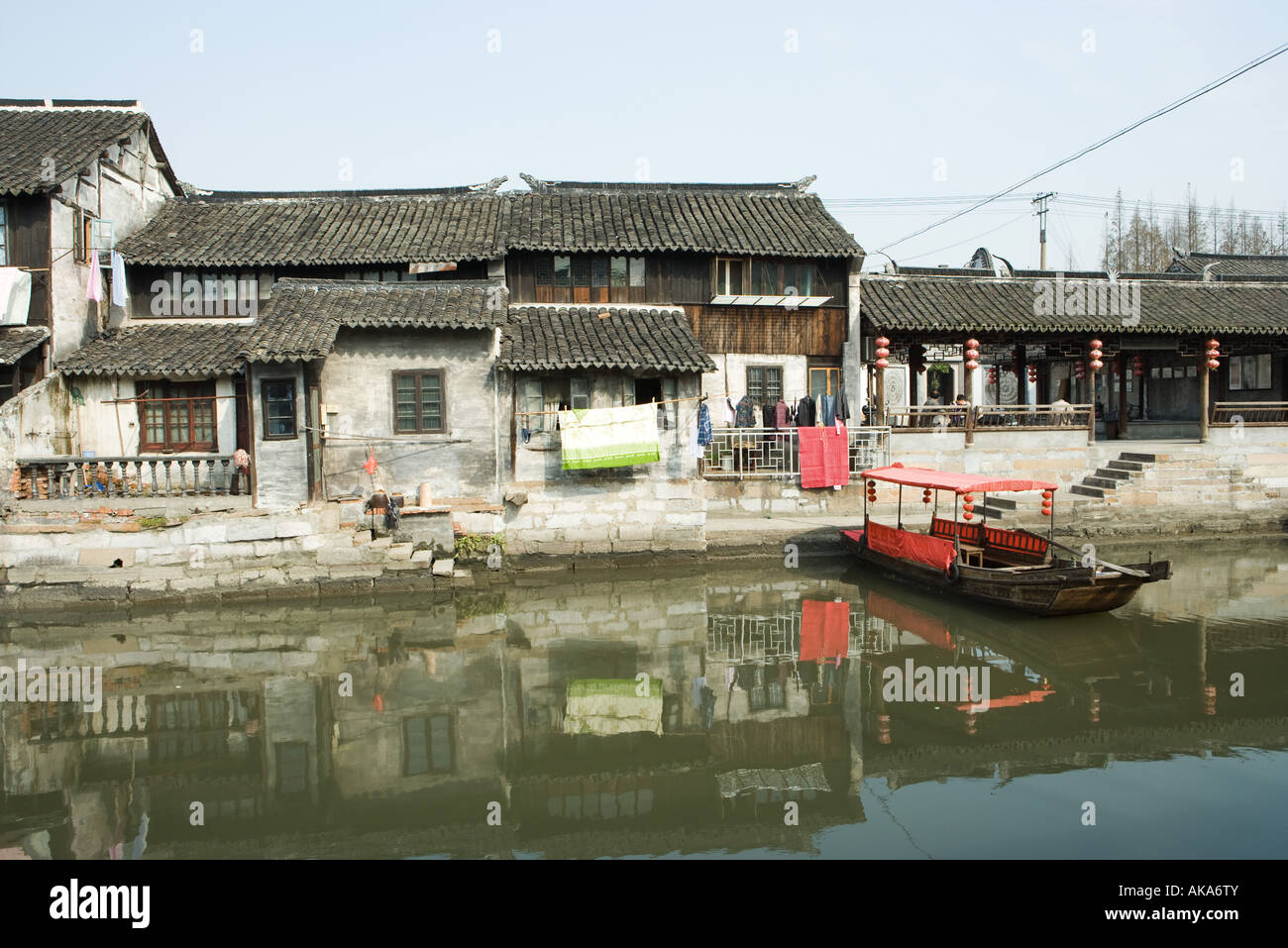 China, Guangdong Province, houses on edge of water, with boat Stock Photo