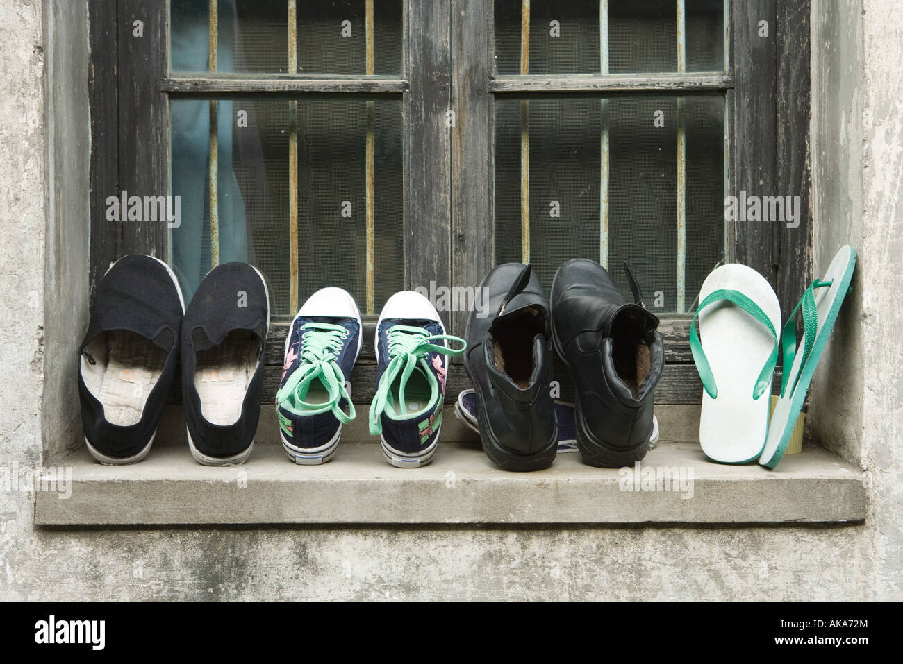 Shoes lined up on windowsill Stock Photo