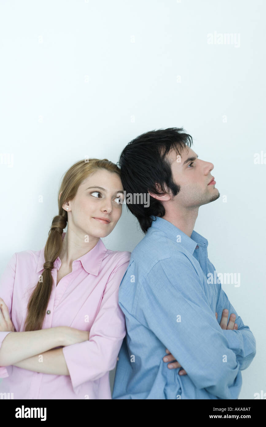 Young couple, man turning back to young woman, arms crossed, waist up, portrait Stock Photo