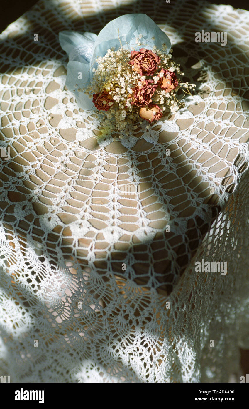 Table with lace table cloth and dried flowers Stock Photo