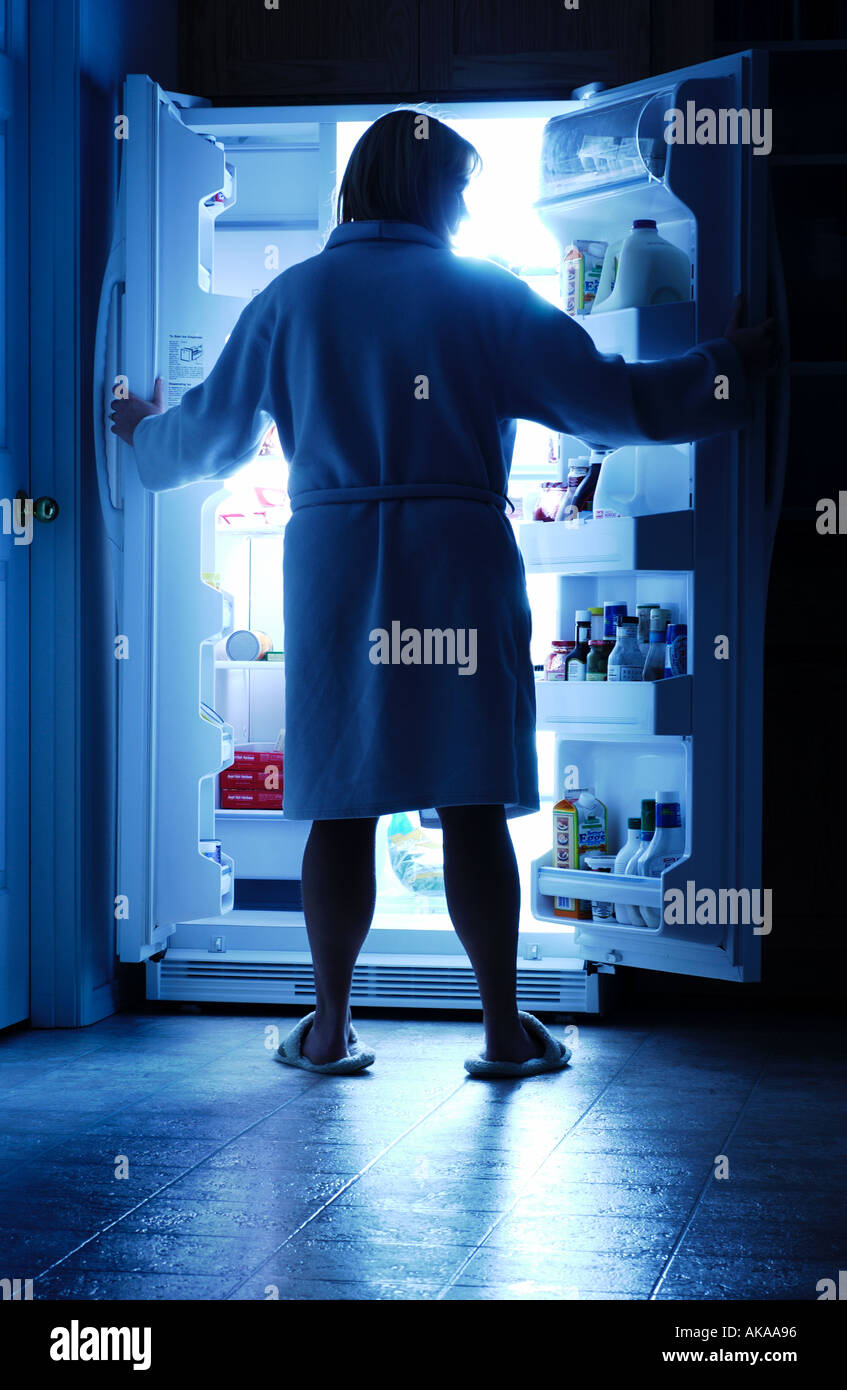 Woman opening refrigerator for a midnight snack Stock Photo Alamy