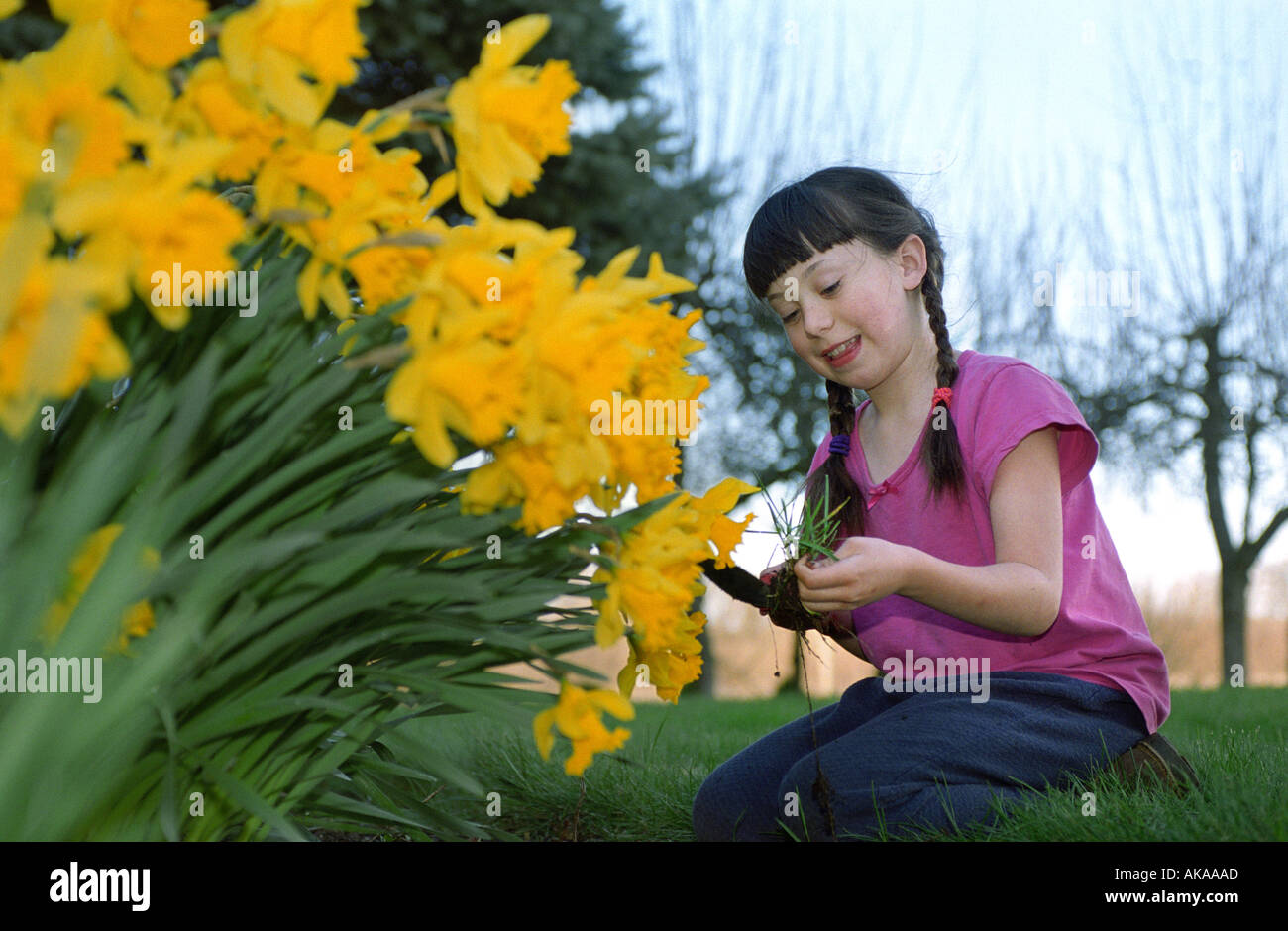 Young girl pulling weeds in flower garden Stock Photo - Alamy