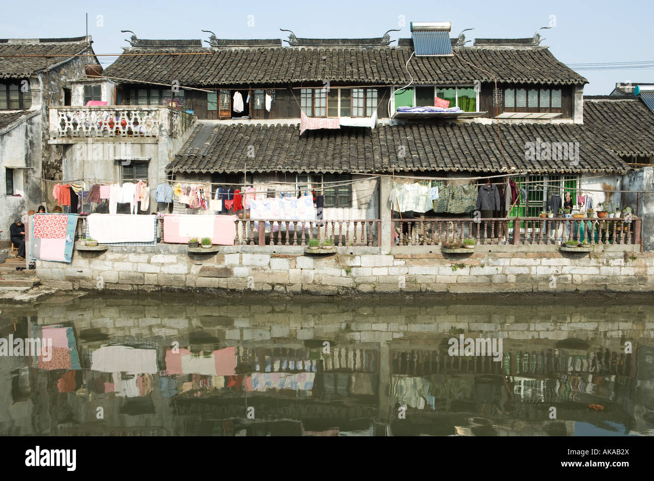 China, Guangdong Province, laundry hanging out in front of houses on edge of water Stock Photo