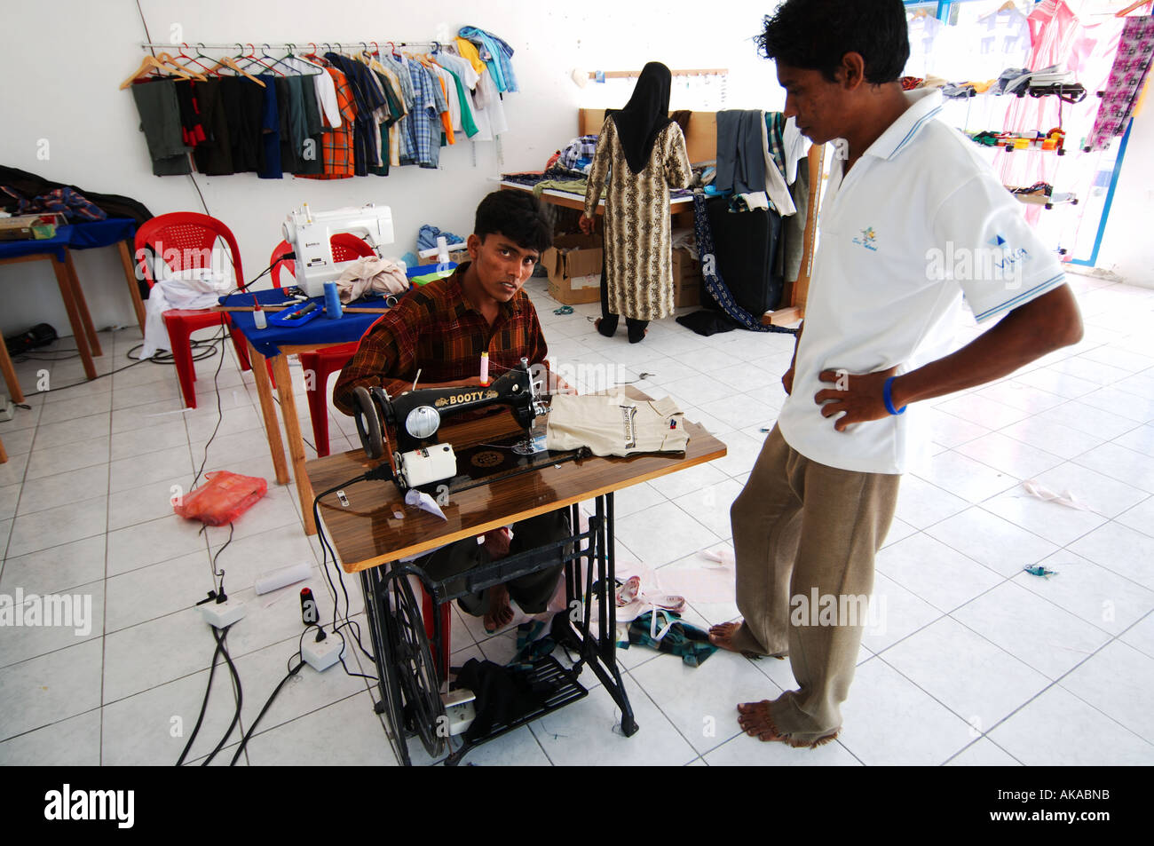Maldives man behind sewing machine Stock Photo