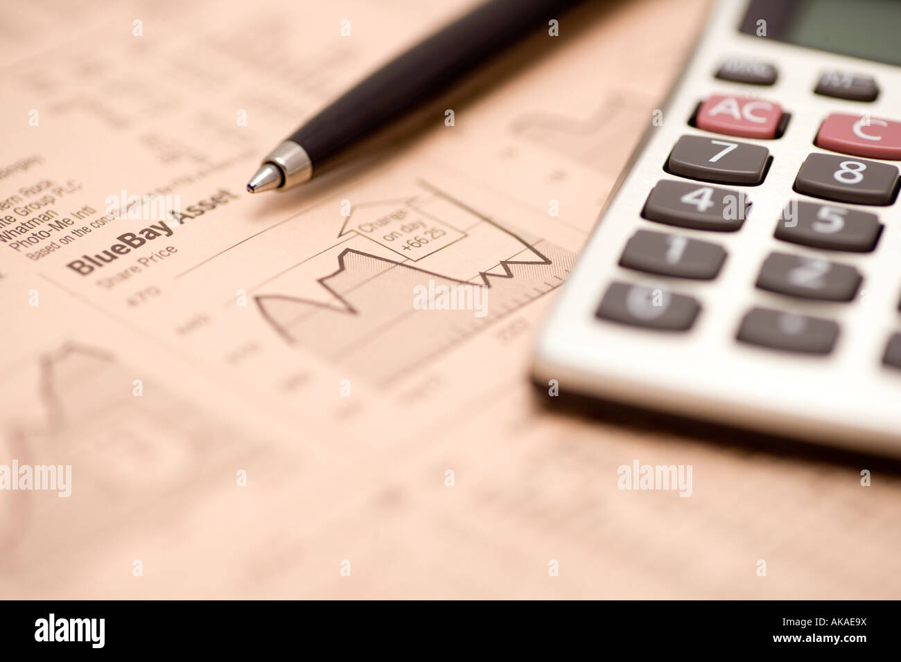 Business newspaper financial pages stocks and shares studying the financial markets with pen and calculator Stock Photo